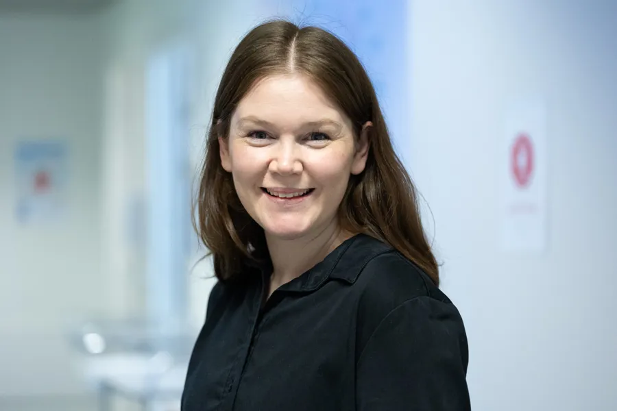 En kvinne som smiler til kameraet