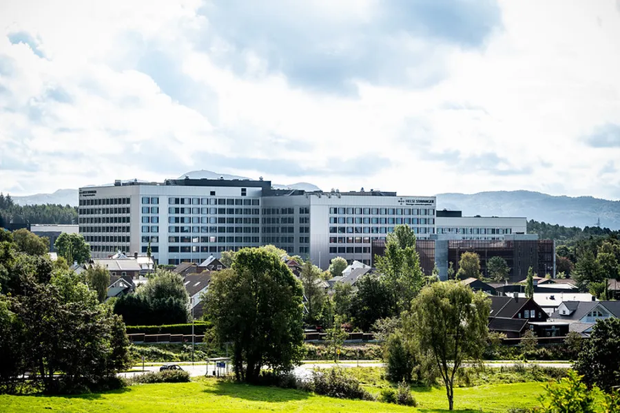 En stor bygning med trær foran seg