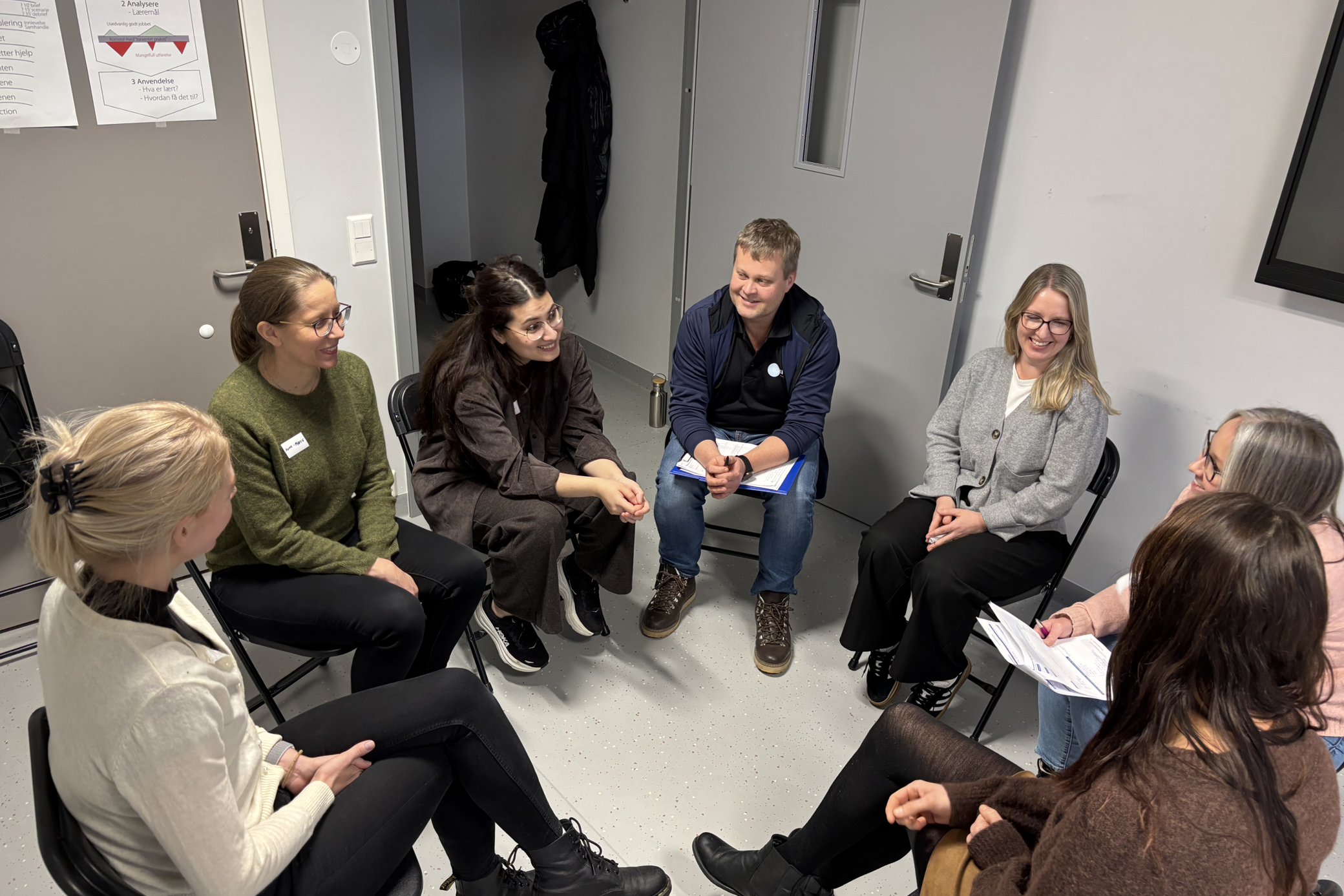 En gruppe mennesker som sitter i stoler