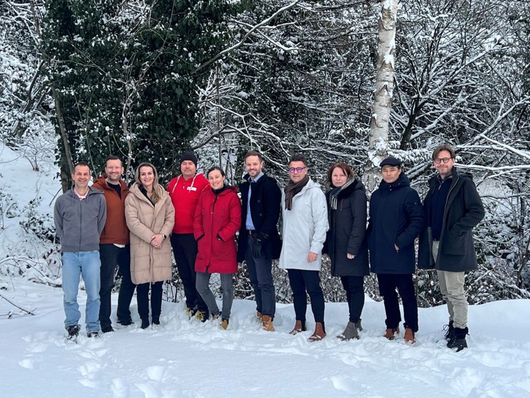 En gruppe mennesker som poserer i snøen