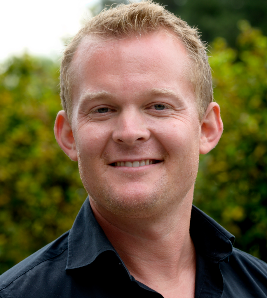 En mann som smiler til kameraet