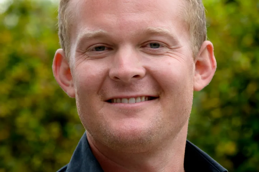 En mann som smiler til kameraet