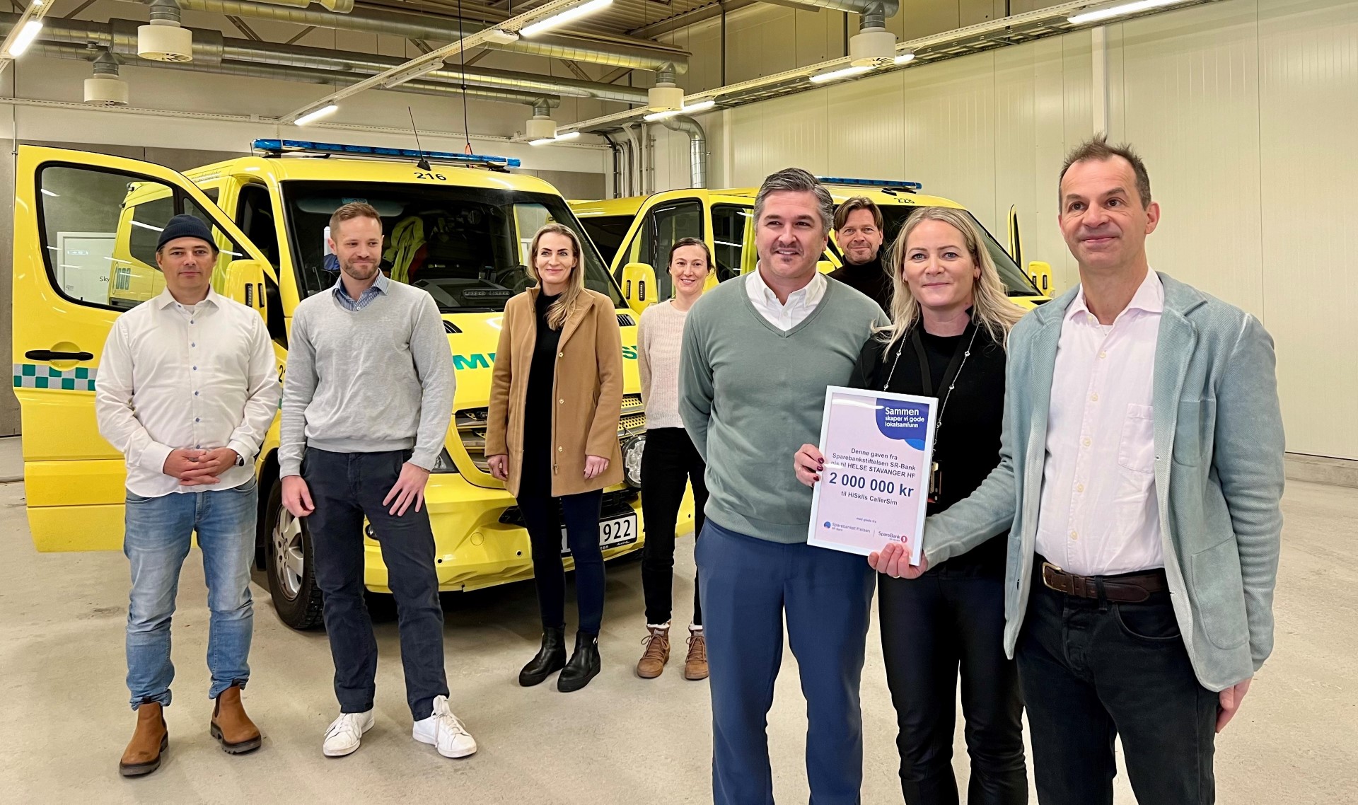 A group of people posing for a photo in front of a yellow truck