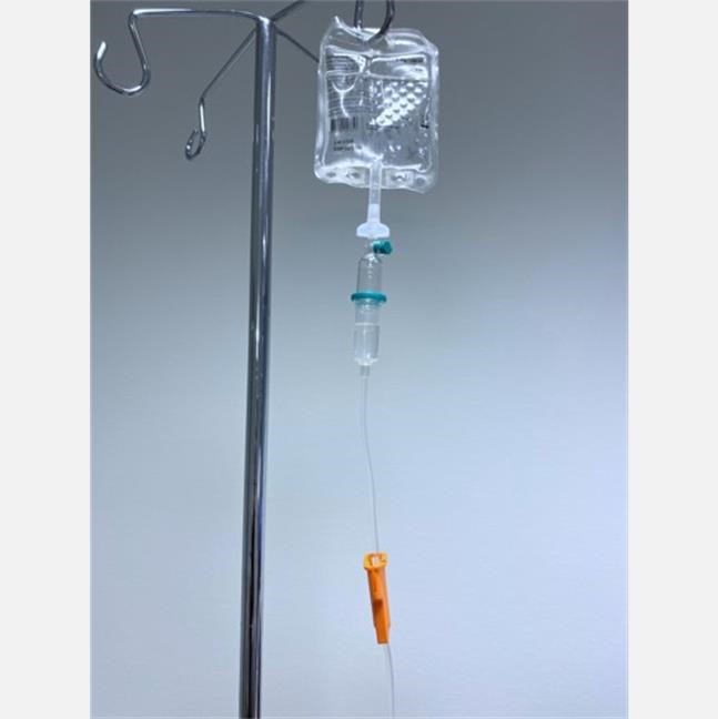 Et nærbilde av en sprøyte som heller væske i et glass