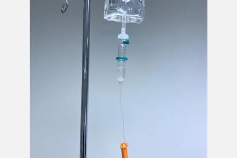 Et nærbilde av en sprøyte som heller væske i et glass