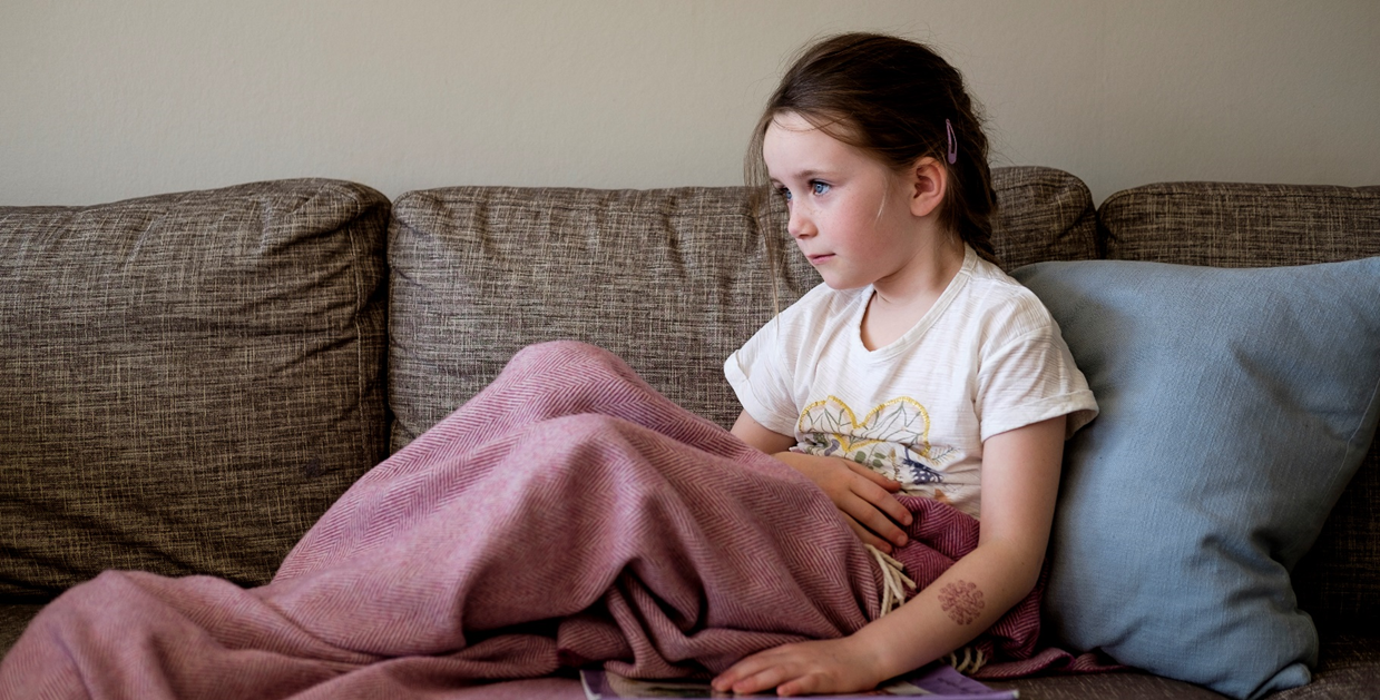 En jente som sitter på en sofa