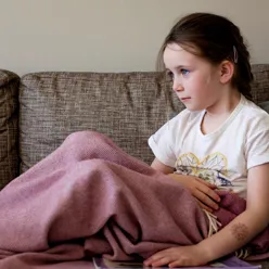 En jente som sitter på en sofa