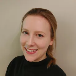 En kvinne som smiler til kameraet