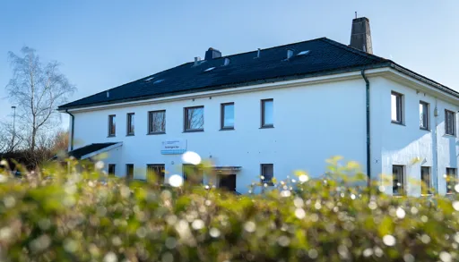 Et hus med en blomstereng foran seg