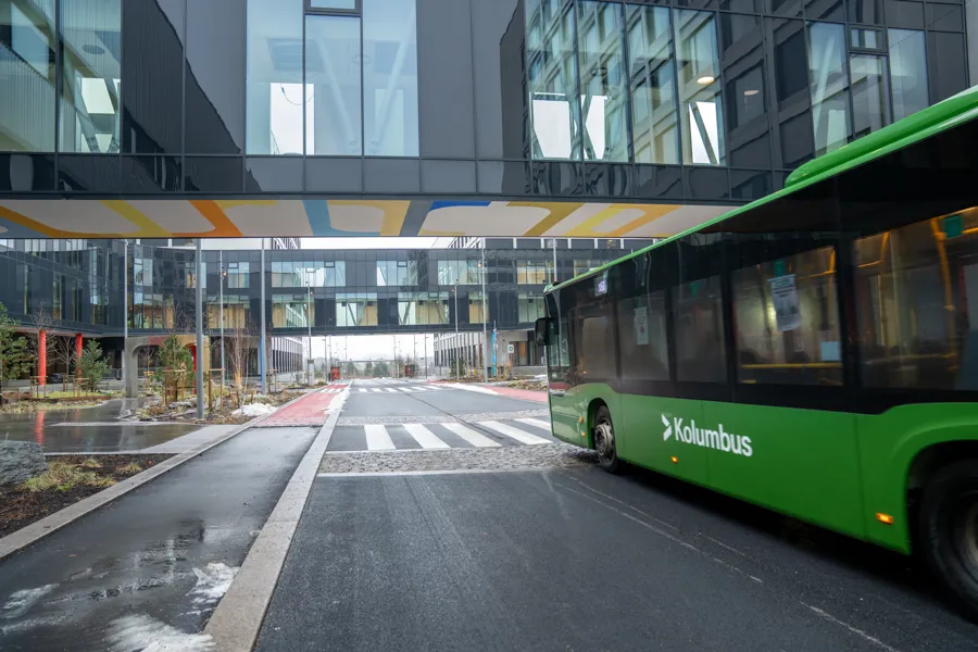 Grønn buss som kjører på en vei