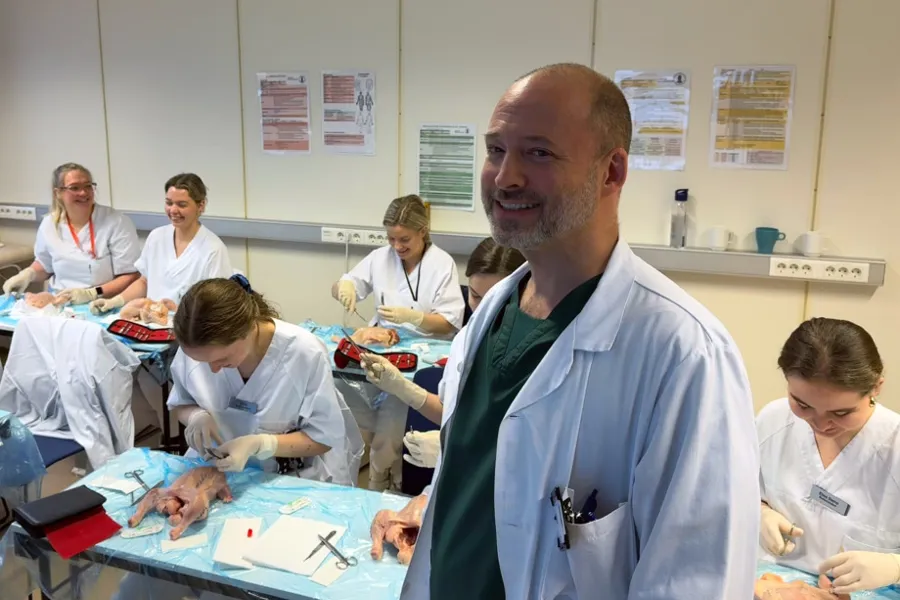 En mann som står foran en gruppe mennesker i et rom