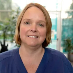 En kvinne som smiler til kameraet