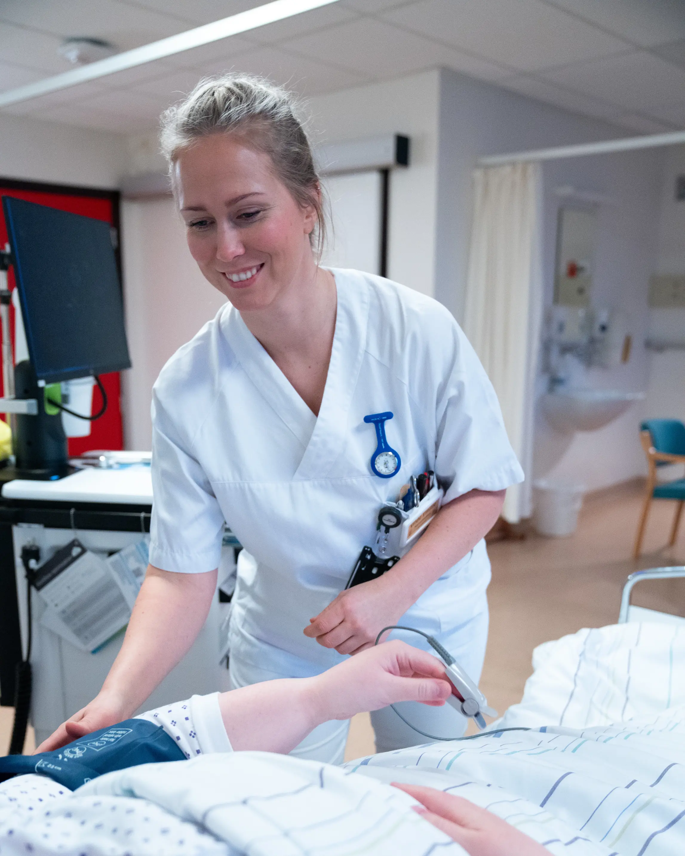 Kvinne i sykepleieruniform tar vare på pasient