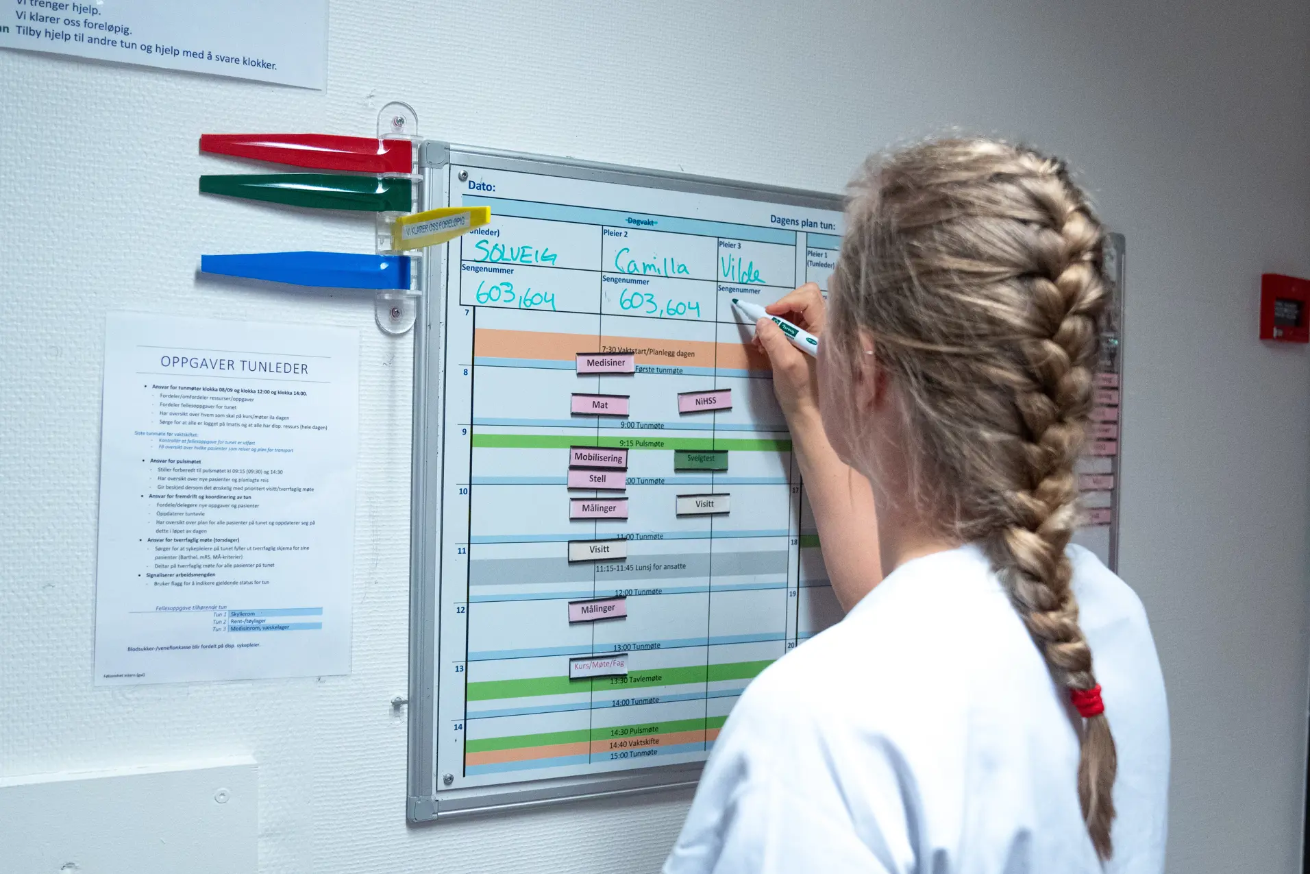 Sykepleier skriver på tavle