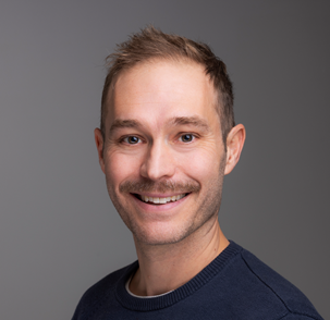 En mann som smiler til kameraet