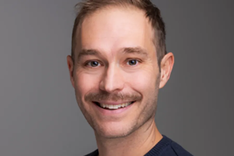 En mann som smiler til kameraet