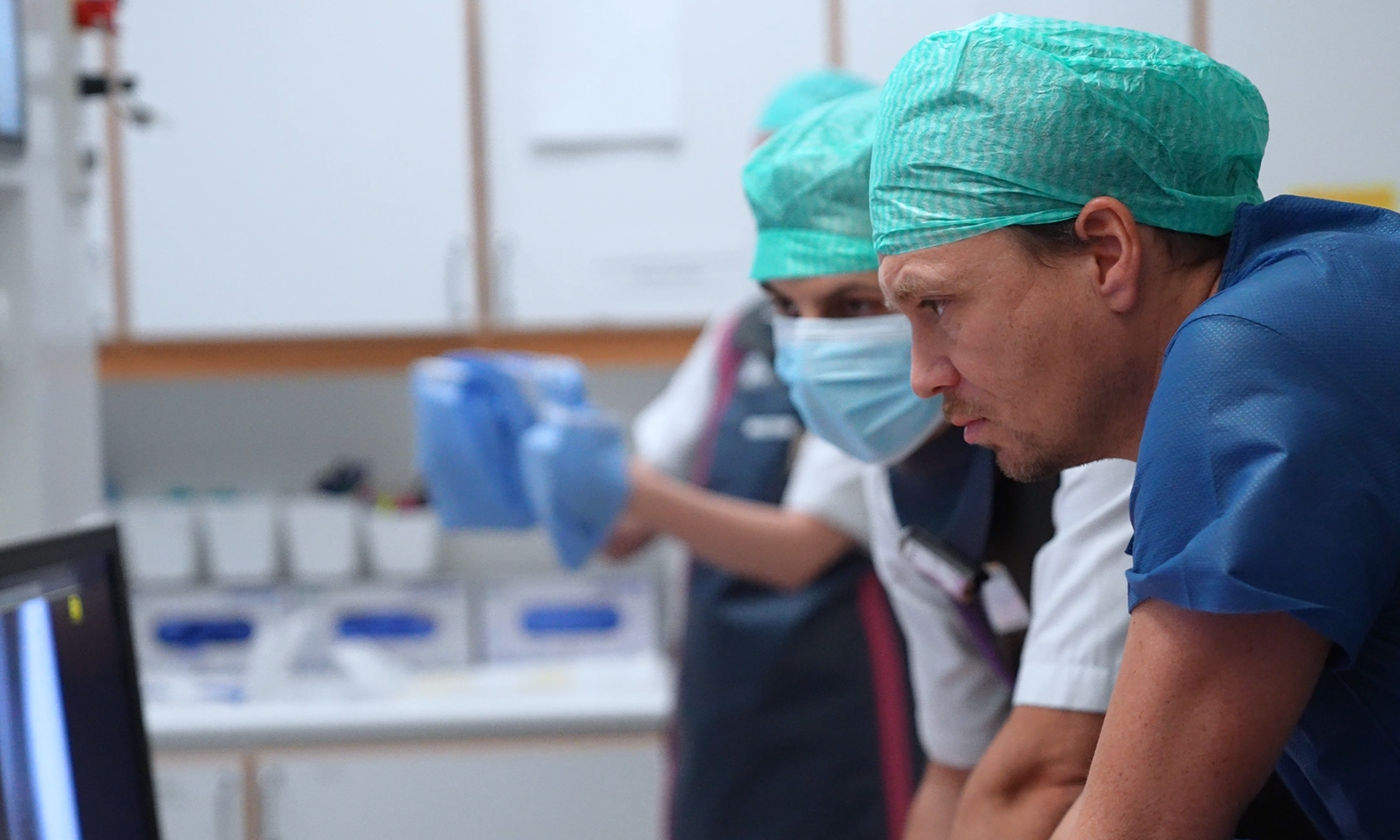 En gruppe mennesker iført kirurgiske skrubber og masker