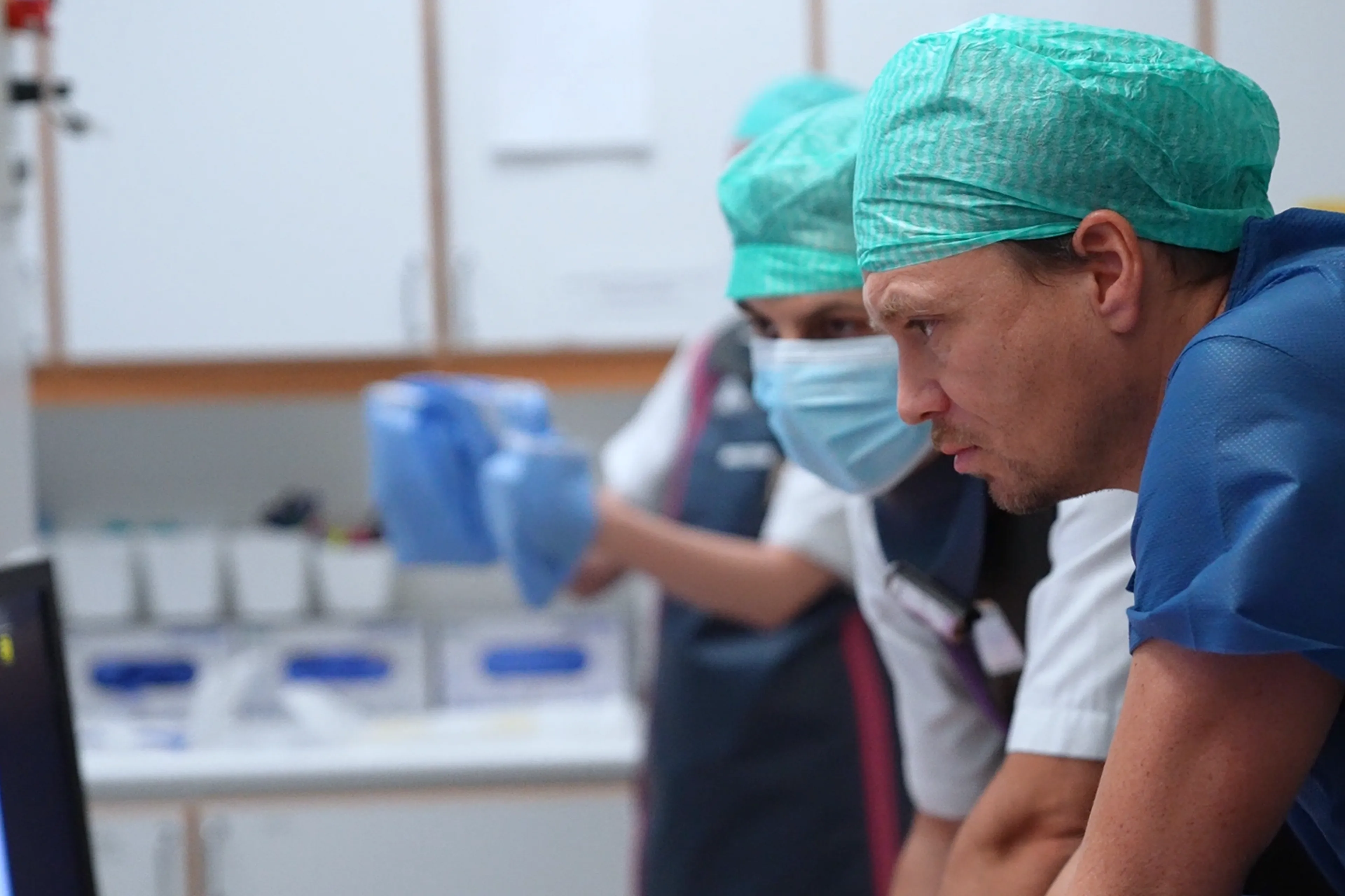 En gruppe mennesker iført kirurgiske skrubber og masker