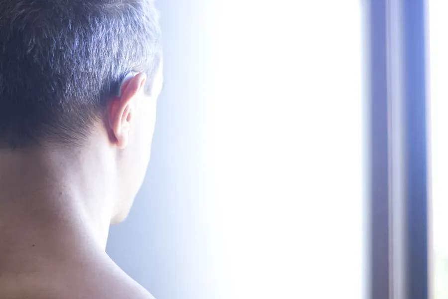 hodet til en mann sett bakfra med høreapparat