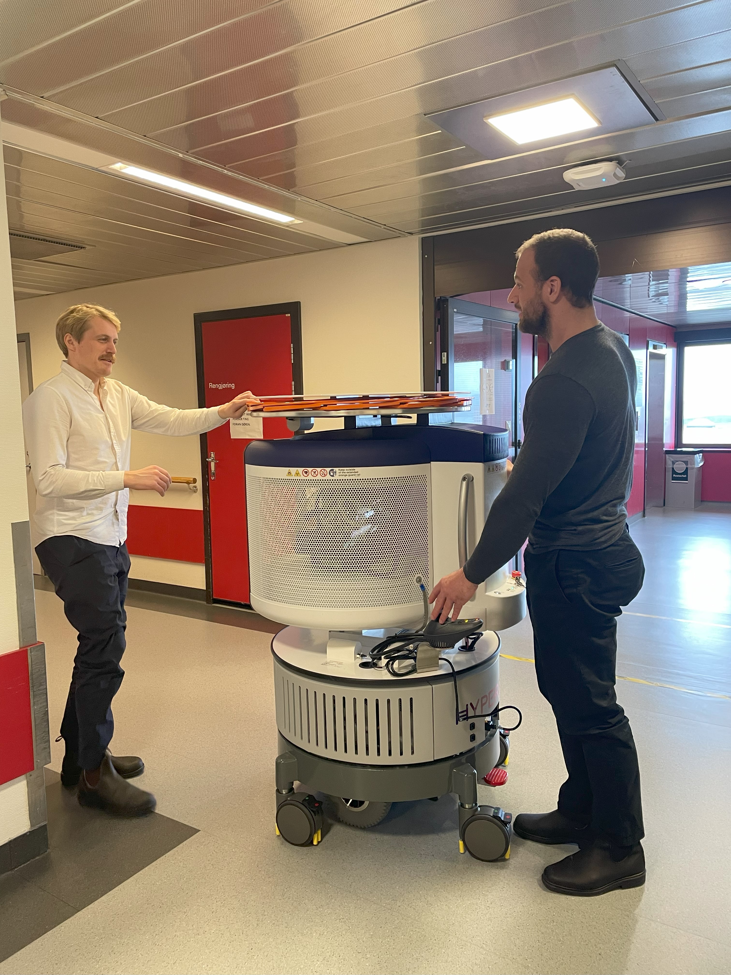 En person som skyver en vogn med en person som står ved siden av seg