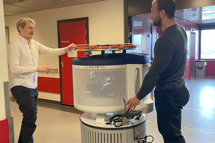 En person som skyver en vogn med en person som står ved siden av seg