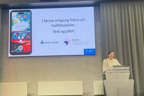 En person som står på et podium foran en storskjerm