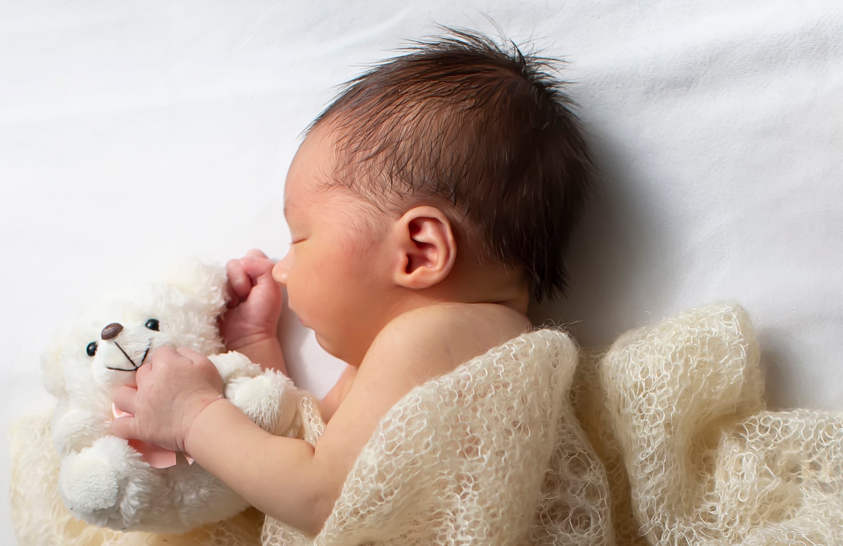 En baby som holder et kosedyr