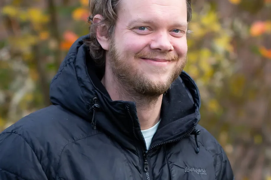 En mann som smiler til kameraet