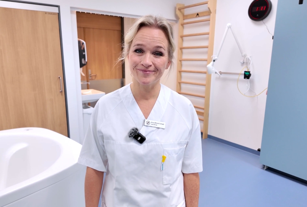 En kvinnelig jordmor som smiler til kamera