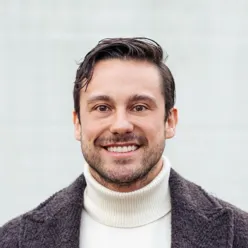 En mann iført en grå genser