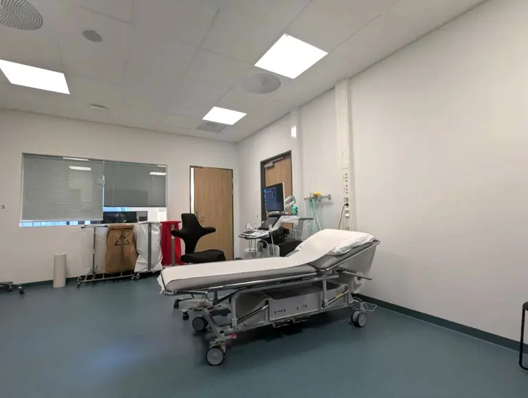 Et sykehusrom med seng og skrivebord