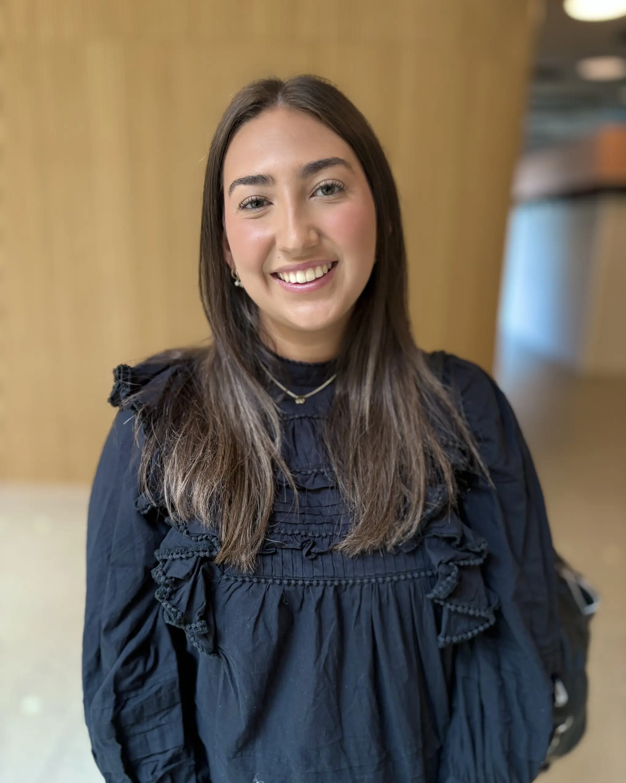 En kvinne som smiler til kameraet