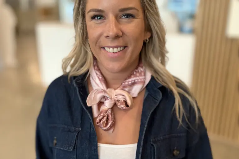 En kvinne iført dress og skjerf