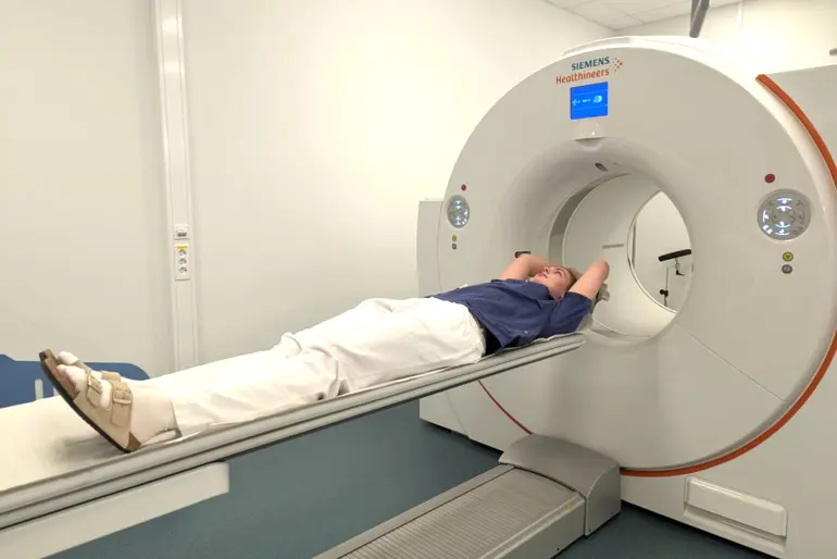 En person som ligger i en PET/CT-maskin