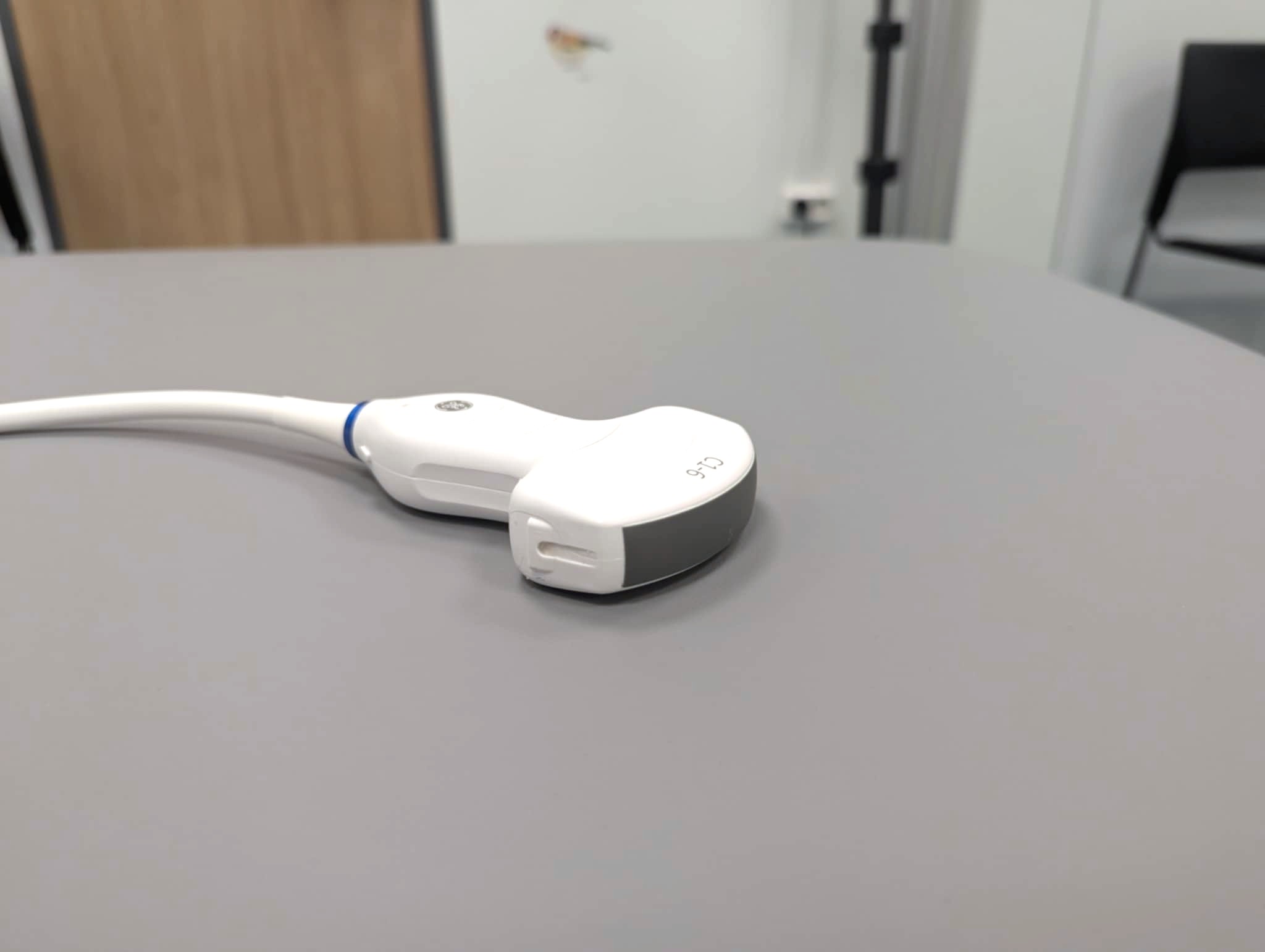 En hvit telefon med ledning på et hvitt bord