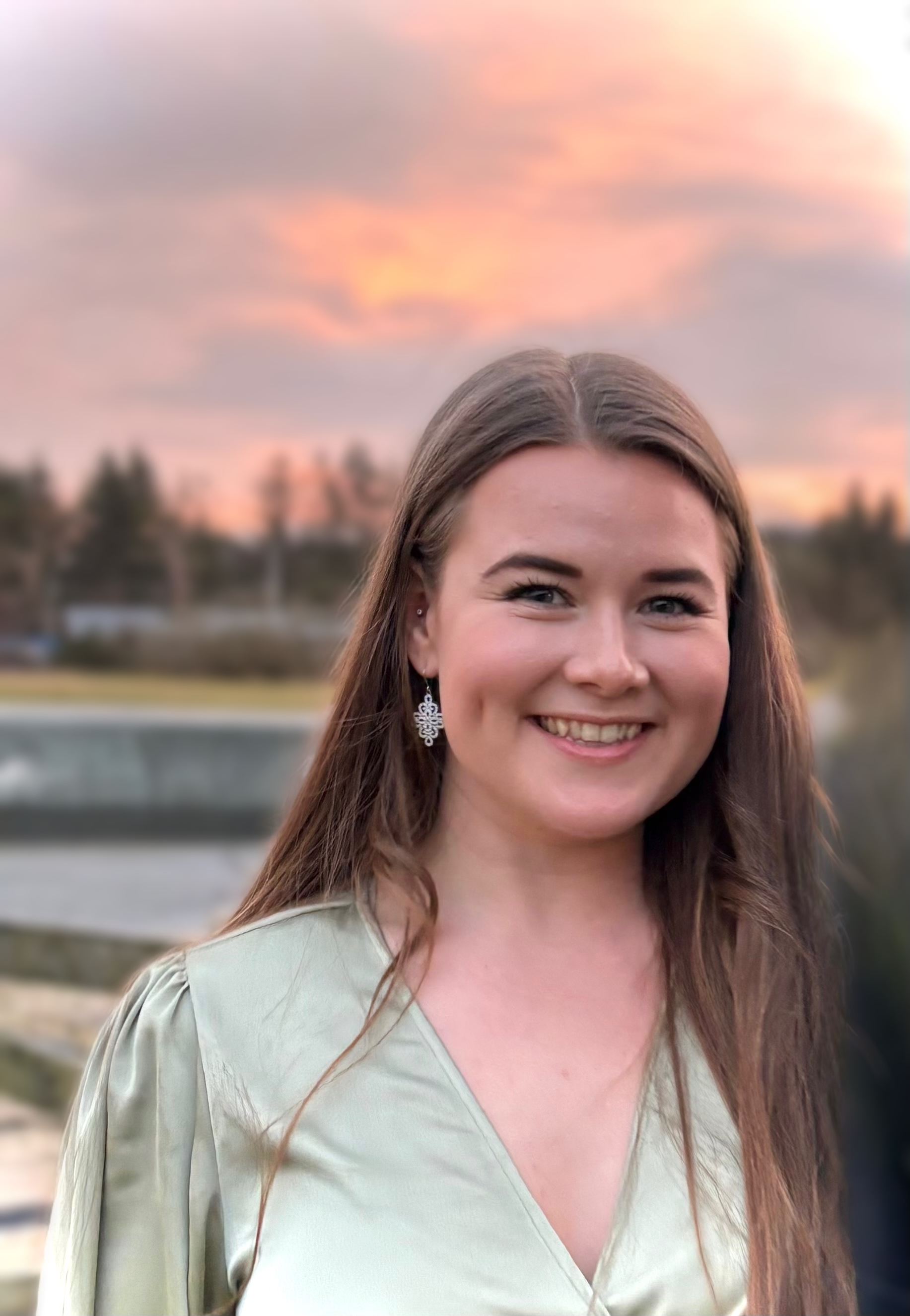 En kvinne som smiler til kameraet