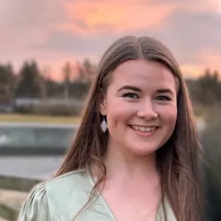 En kvinne som smiler til kameraet