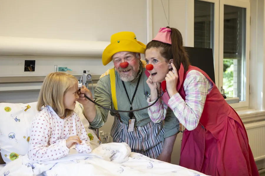 Sykehusklovner med et barn i en sykeseng