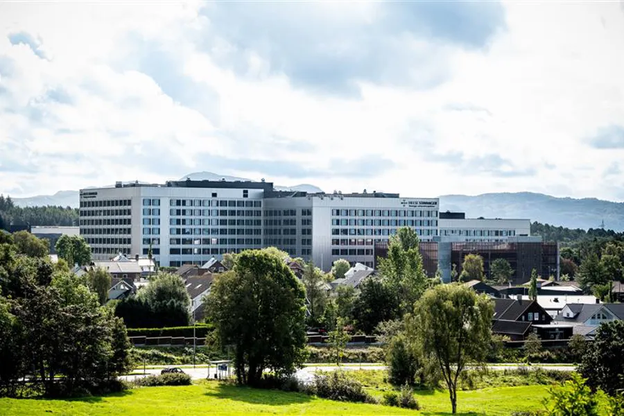 En stor bygning med trær foran seg