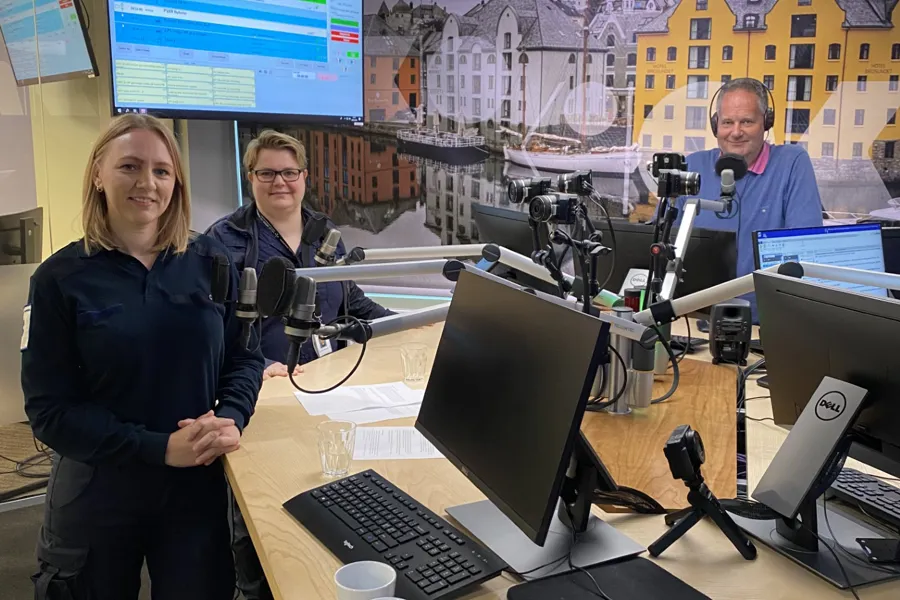 A few people standing in front of computers