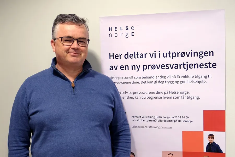 En mann som står foran et skilt