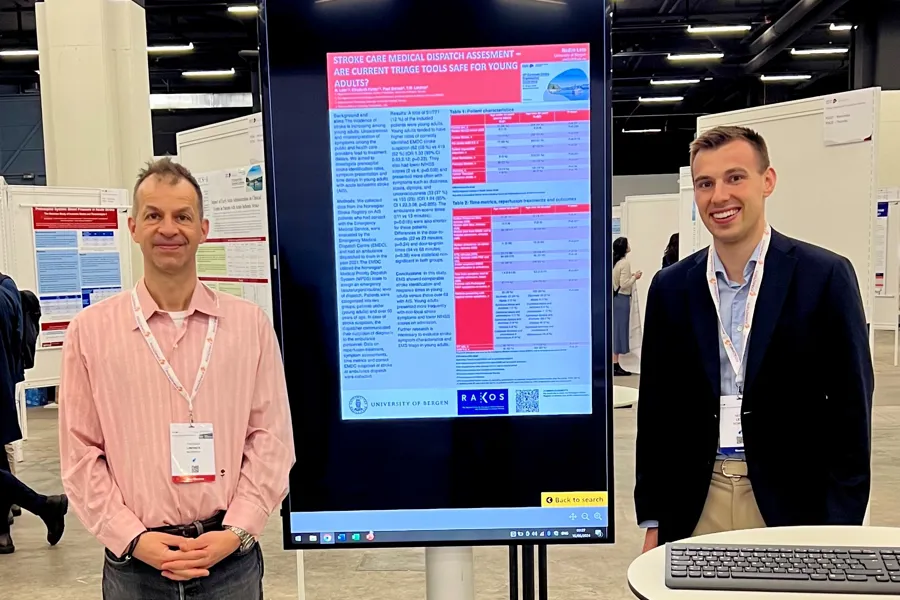 Noen menn som står ved siden av en stor skjerm