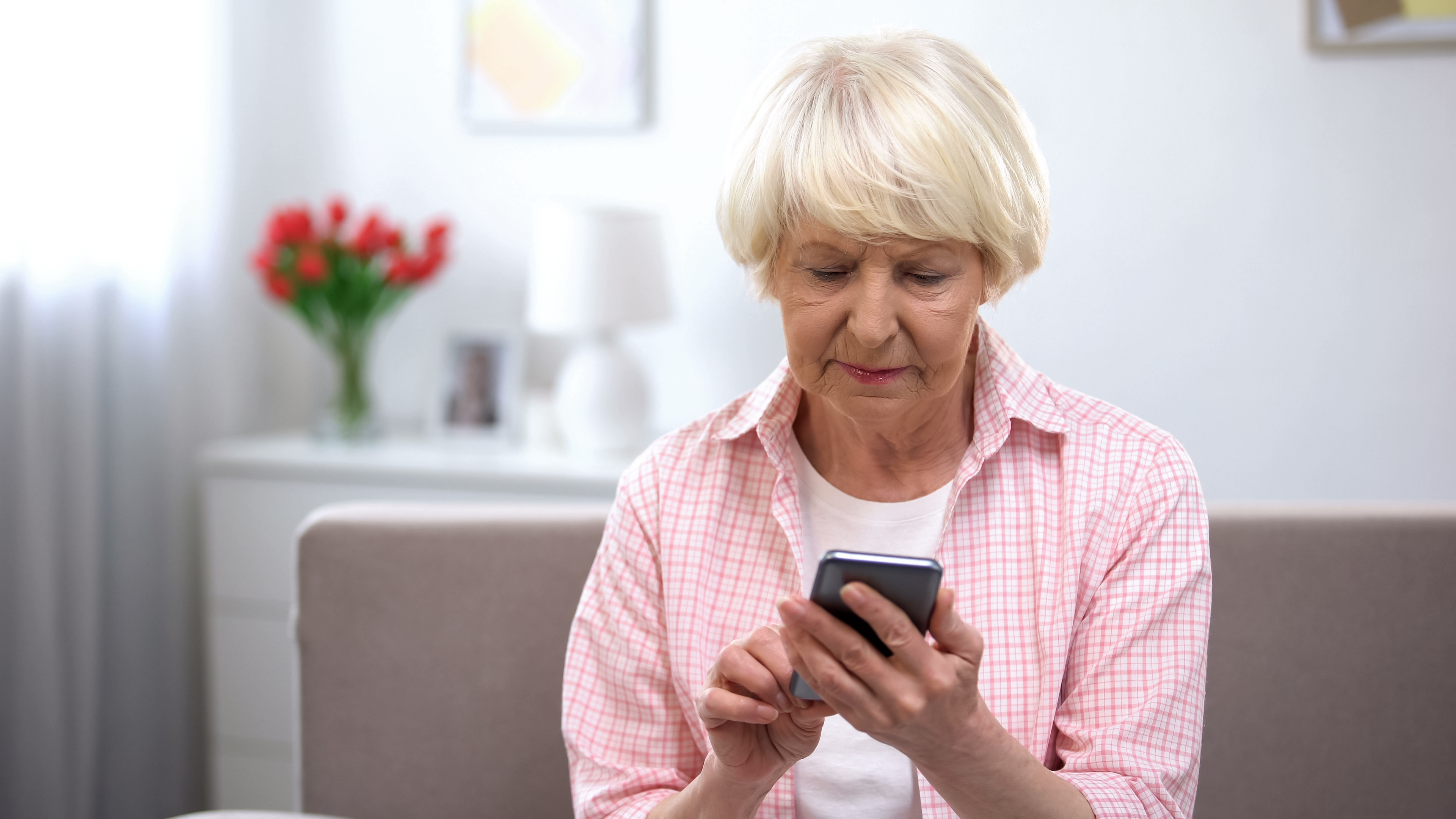 En eldre dame som ser på telefonen