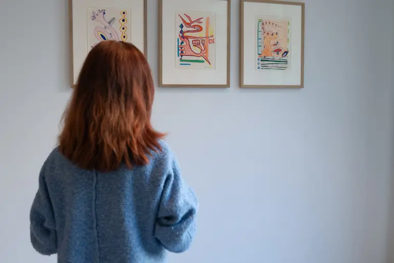 En person som ser på kunst på en vegg