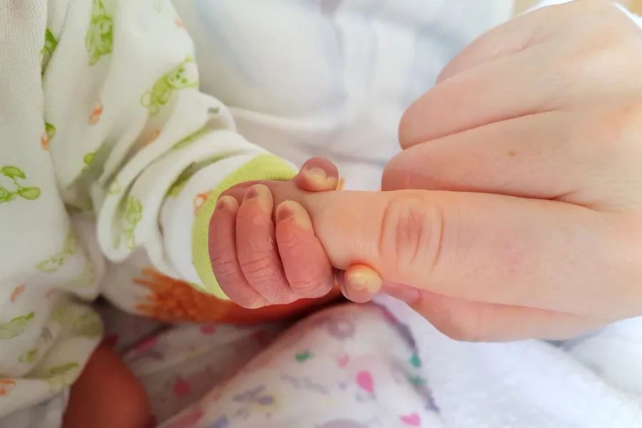 En babyfot med et rosa og hvitt teppe