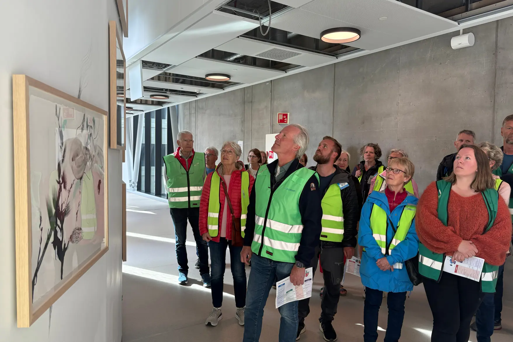 En gruppe mennesker i sikkerhetsvester som står i en gang