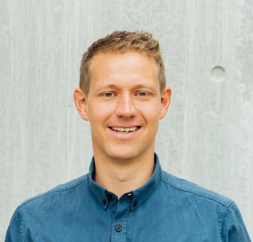 En mann som smiler til kameraet