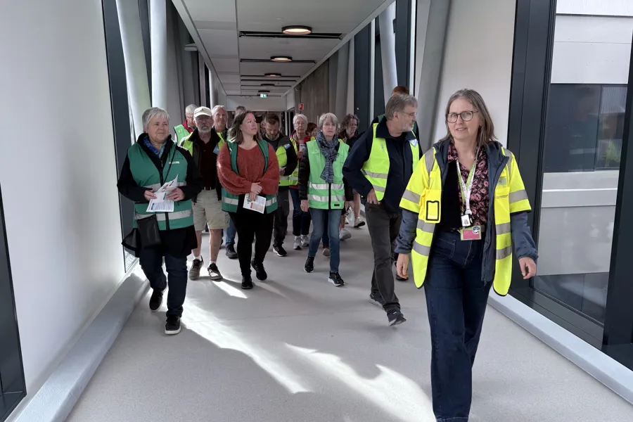 Flere personer som går med grønne vester.