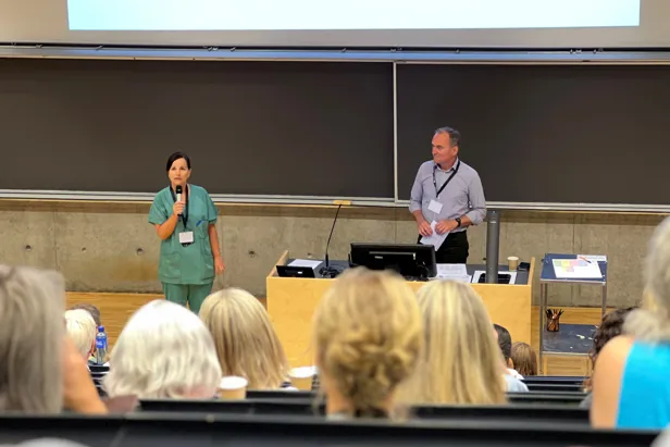 En mann og kvinne som står foran en folkemengde