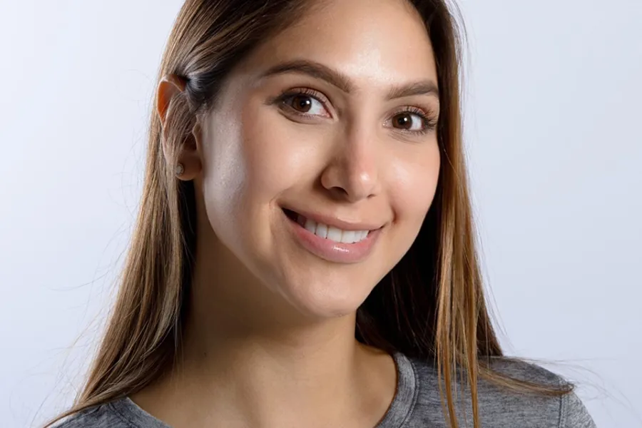 En kvinne som smiler til kameraet